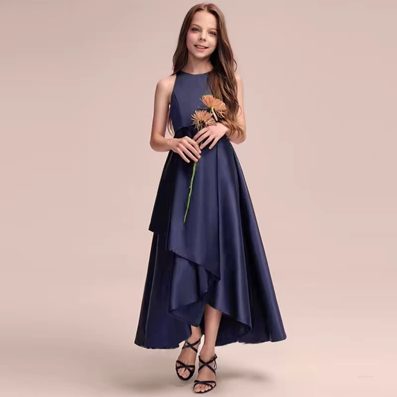 Girl in navy blue high-low dress with halter neck holding flowers and wearing strappy heels.