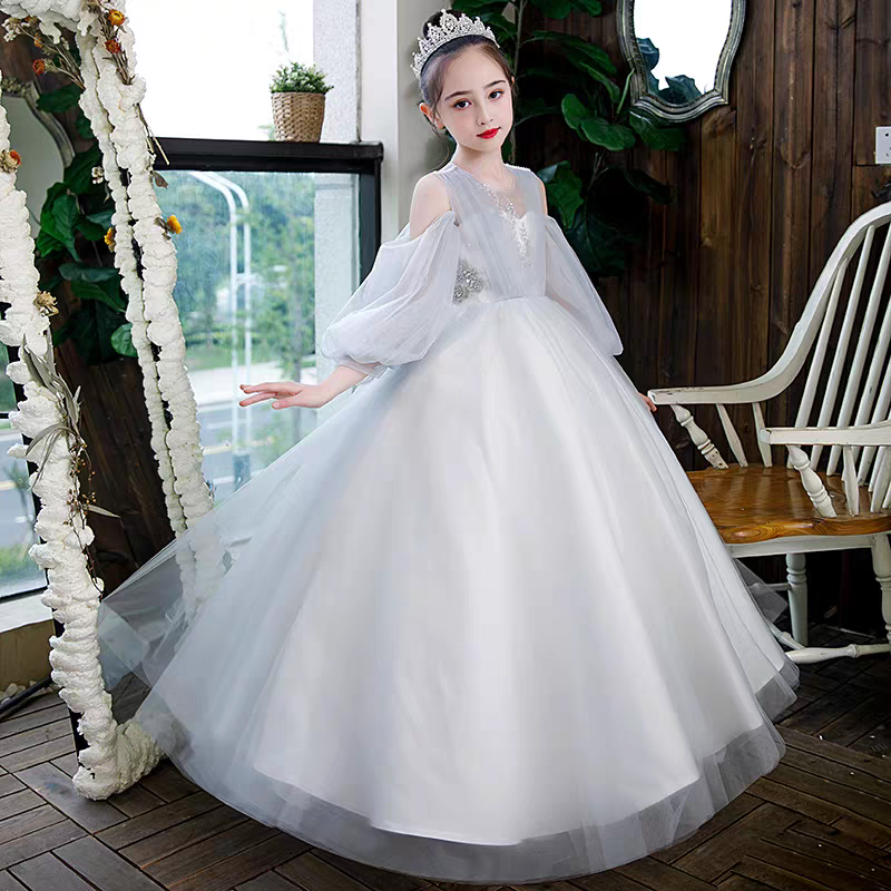 Girl in white tulle formal dress with off-the-shoulder puff sleeves and tiara.