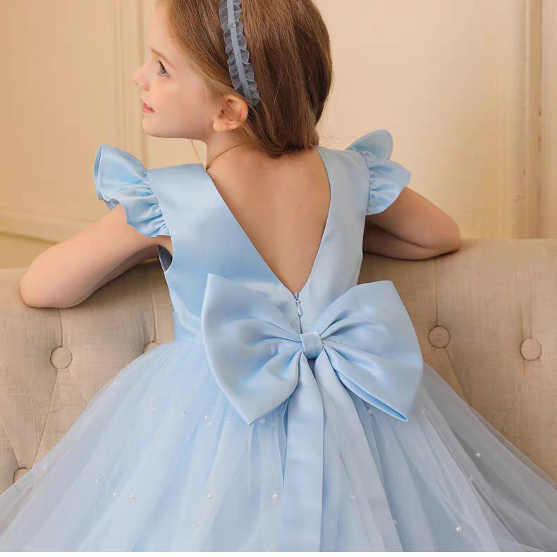 Girl in light blue dress with large bow and pearl accents. Party dress with V-back.