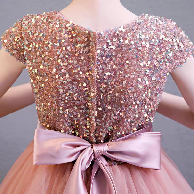 Back view of a pink sequined party dress with a satin bow.