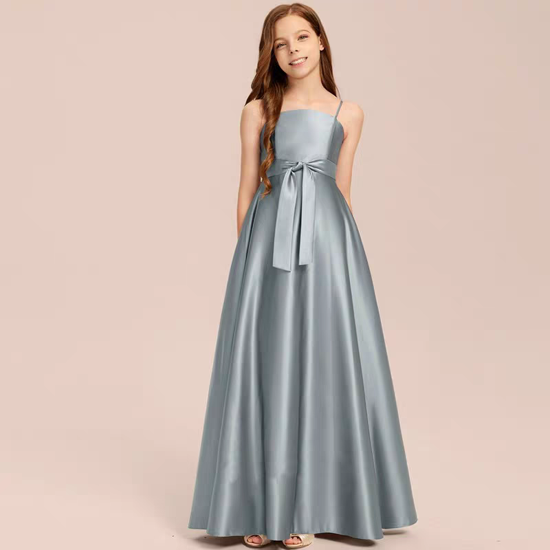 Girl wearing a floor-length, A-line, silver formal dress with spaghetti straps and a matching sash.