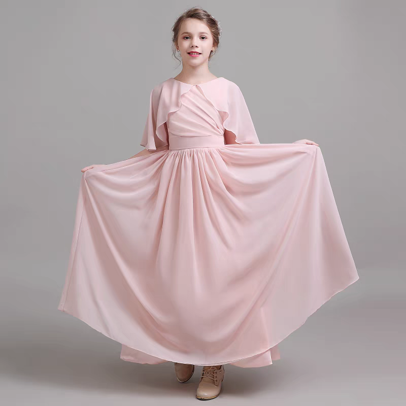 Girl in flowing pink chiffon dress with capelet sleeves for formal events.