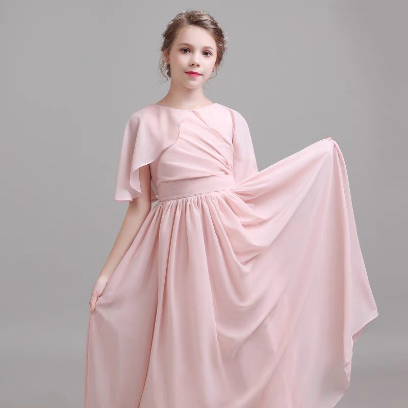 Girl in a flowing pink chiffon formal dress with capelet sleeves.