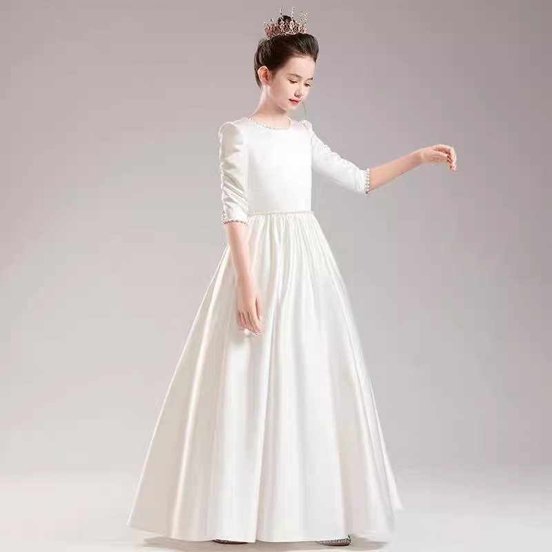 Girl in elegant white dress with beaded details and crown for special occasions.