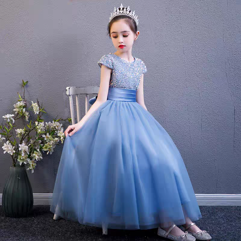 Girl wearing a blue sequined bodice tulle gown with tiara and silver shoes