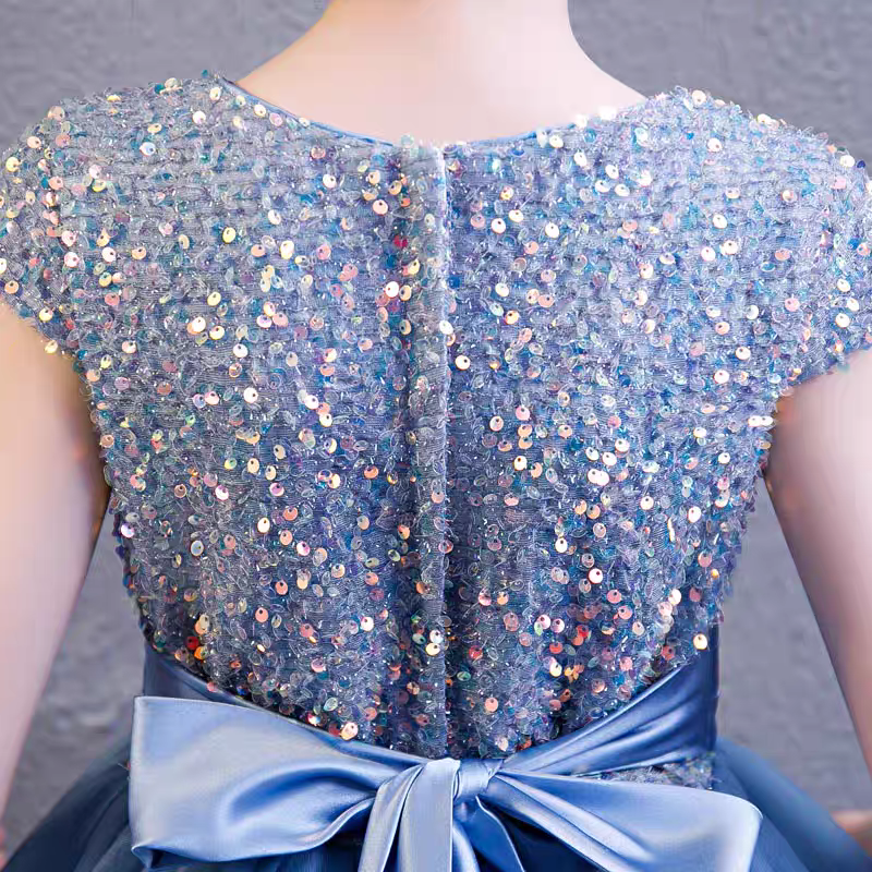 Back view of a blue sequined party dress with a satin bow.