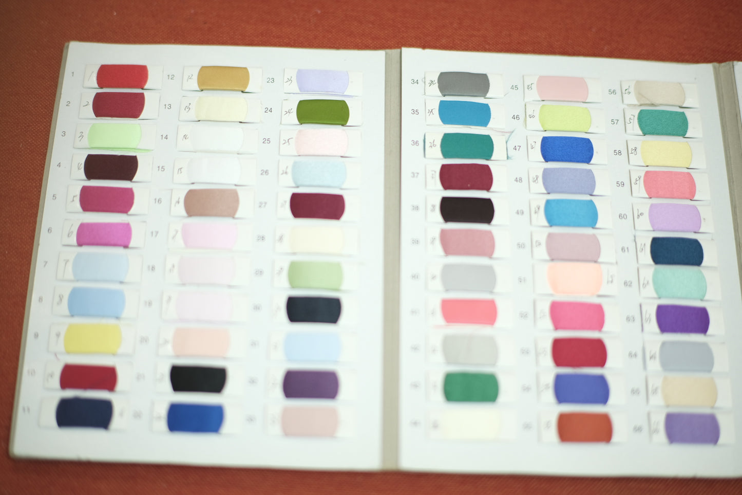 Fabric swatch book showing assorted textile color samples.