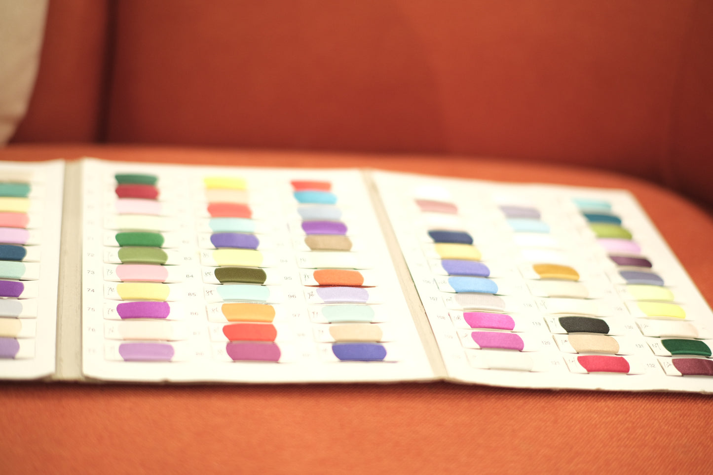 Open swatch book displaying colorful fabric samples for textile selection.