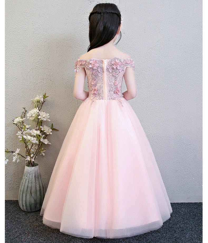 Back view of a girl in a pink off-the-shoulder formal dress with floral accents on the bodice.