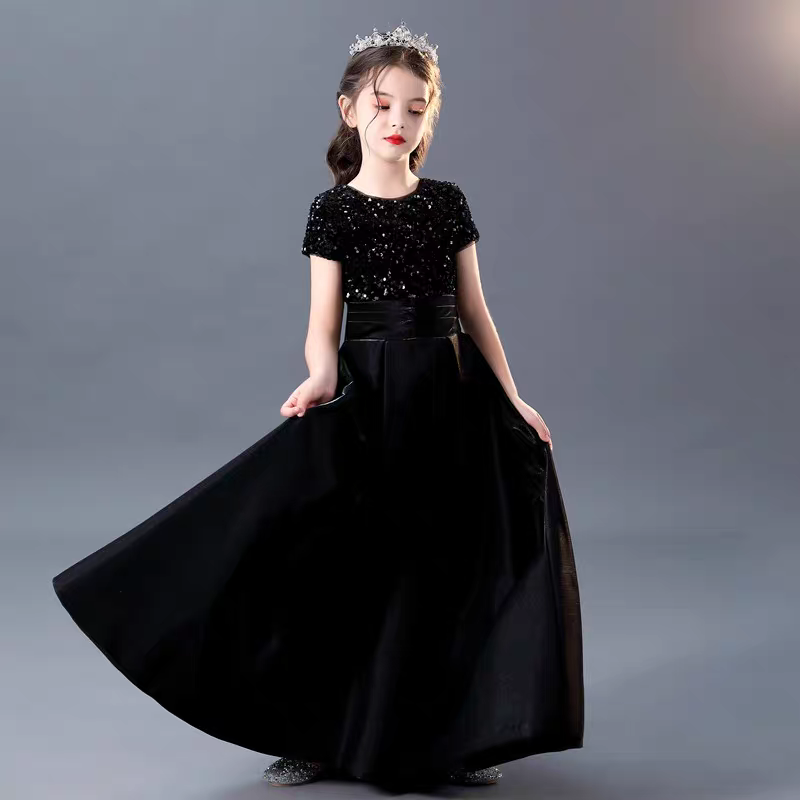 Girl in elegant black sequin dress with flowing skirt and tiara, perfect for special occasions.