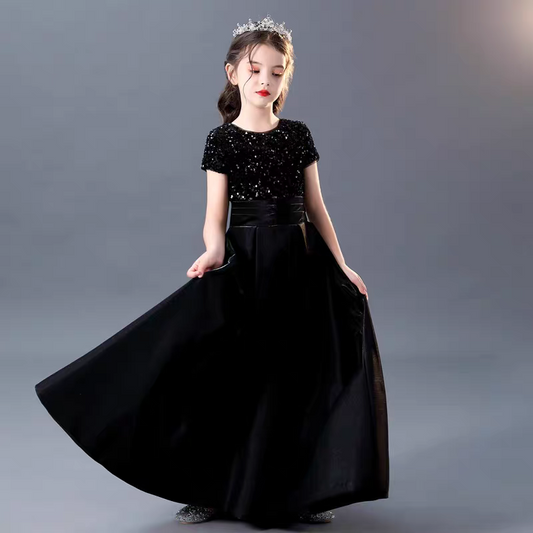 Girl in elegant black sequin dress with flowing skirt and tiara, perfect for special occasions.