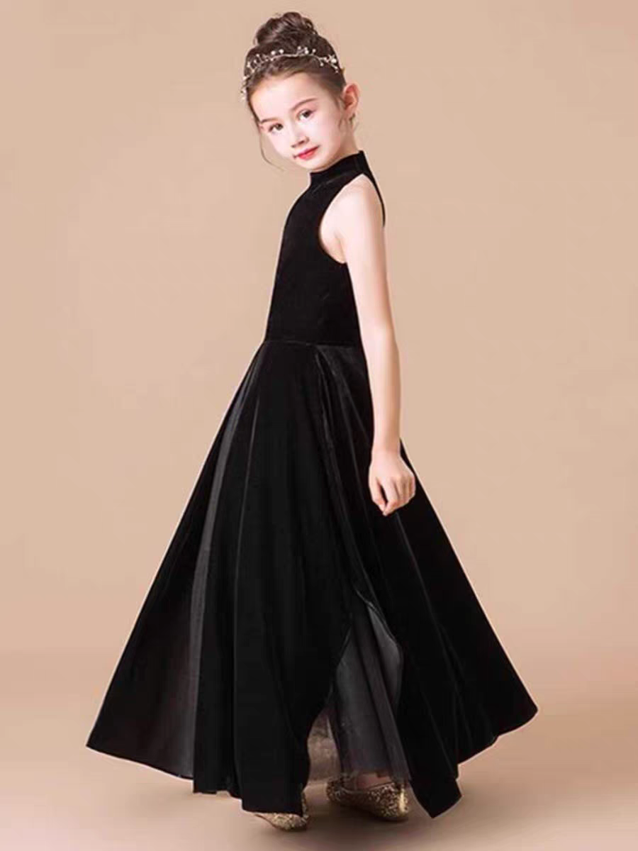 Girl wearing a sleeveless black velvet A-line dress with a high neckline and delicate headband.