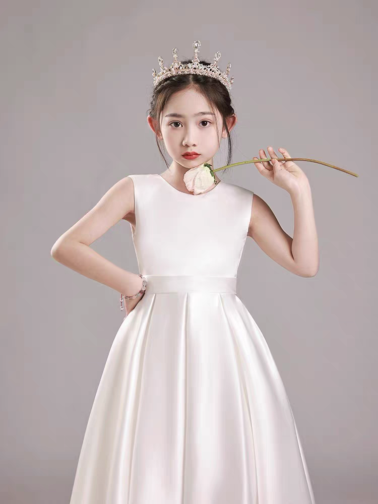 Girl in white dress and crown holding rose, perfect for flower girl or special occasion.