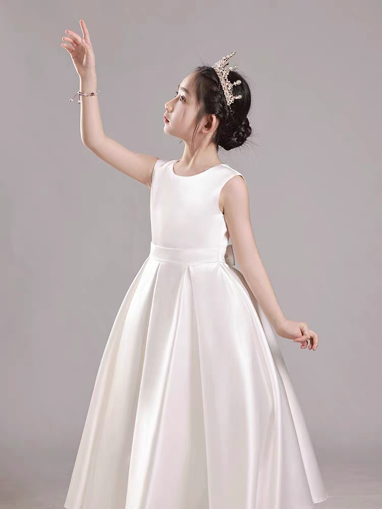 Girl in elegant white dress with crown, sleeveless satin formal dress.