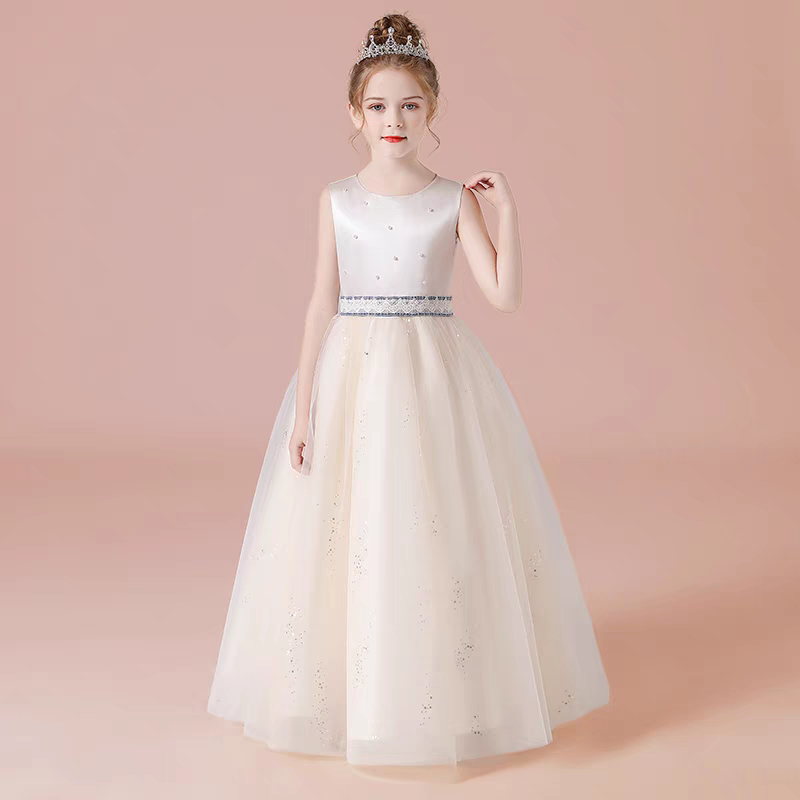 Girl in an ivory tulle flower girl dress with jeweled belt and tiara.