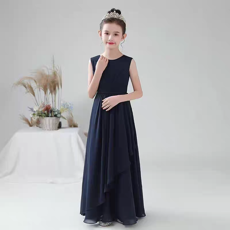 Girl in a navy blue sleeveless formal dress with a tiara. Full length.