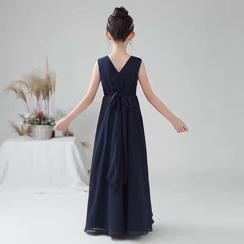 Back view of a girl wearing a navy blue formal dress with V-neck and sash.