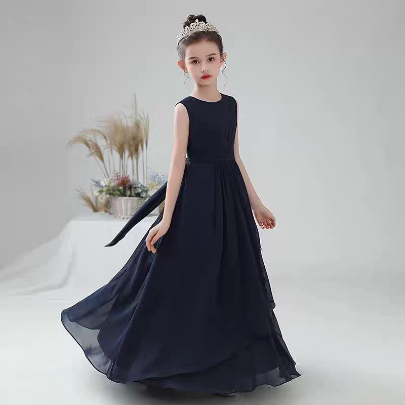 Girl in flowing navy blue chiffon dress with a crown, sash detail. Elegant occasion wear.