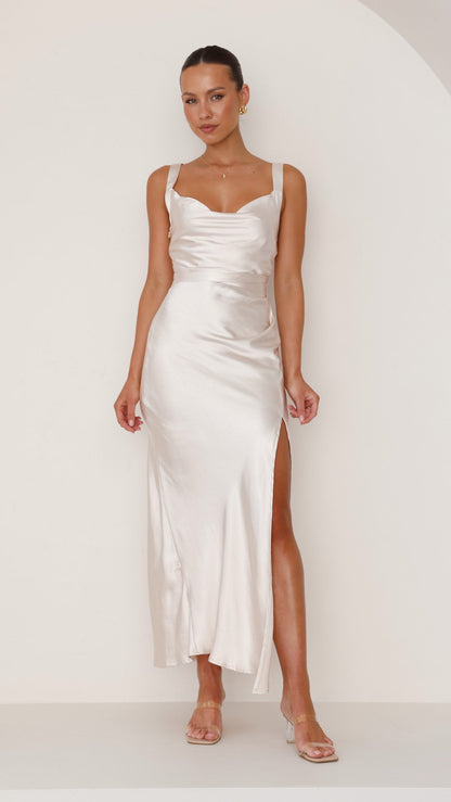 Champagne satin maxi dress with cowl neck, side slit, and sleeveless design.