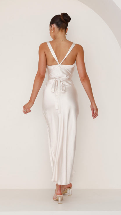 Back view of a champagne-colored maxi dress with straps and tie-back detail.