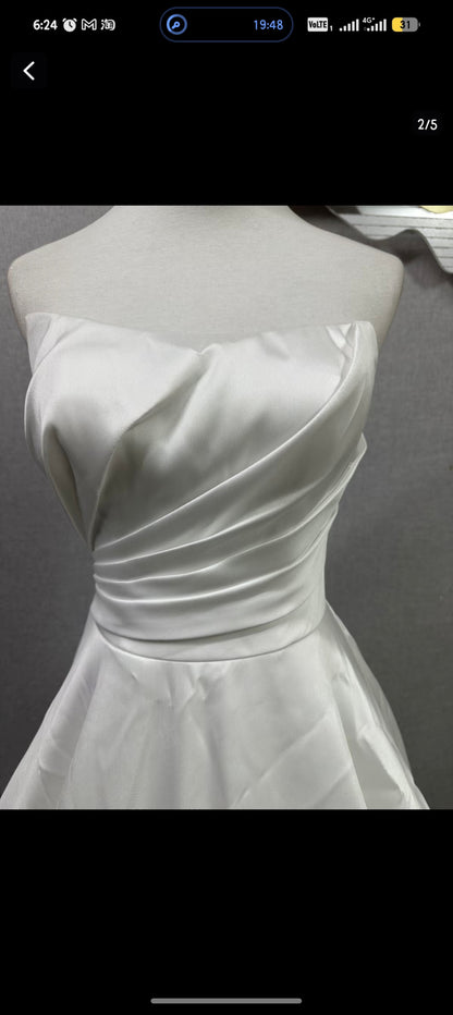 Original reference photograph of strapless pleated off-white Mikado satin wedding gown, front bodice close-up.