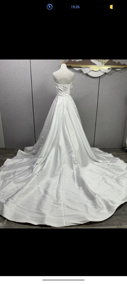 Original reference photograph of strapless pleated off-white Mikado satin wedding gown, full back and train.